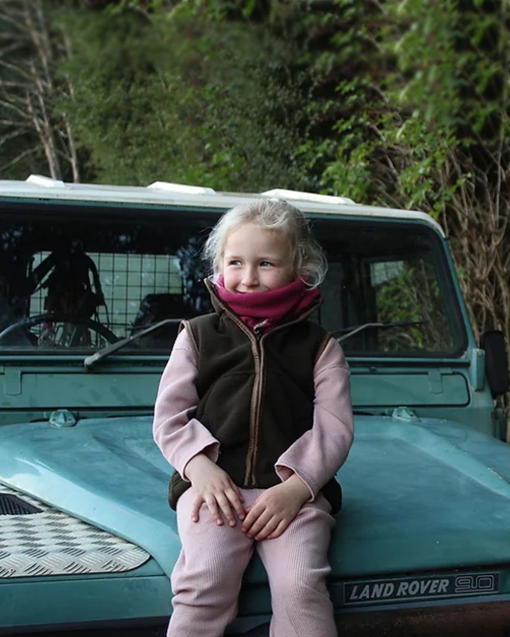 Dark Olive coloured Jack Pyke Junior Countryman Gilet on forest background #colour_dark-olive