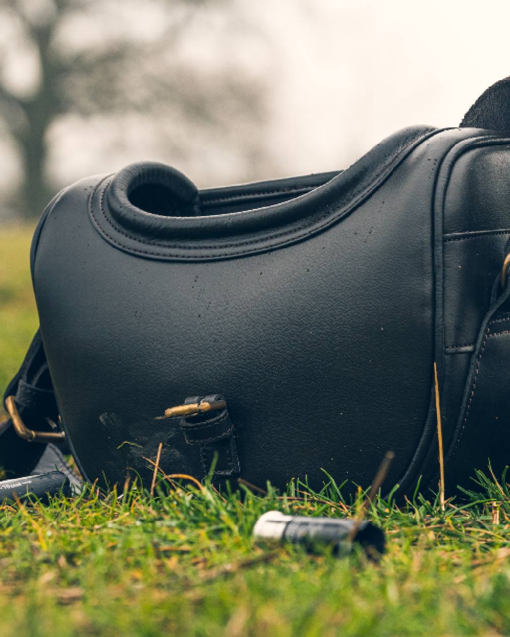Brown coloured Jack Pyke Leather Cartridge Bag on grass background #colour_brown