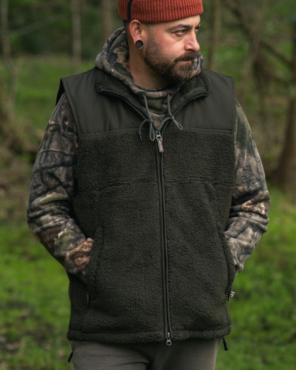 Dark Olive coloured Jack Pyke Sherpa Fleece Gilet on forest background #colour_dark-olive
