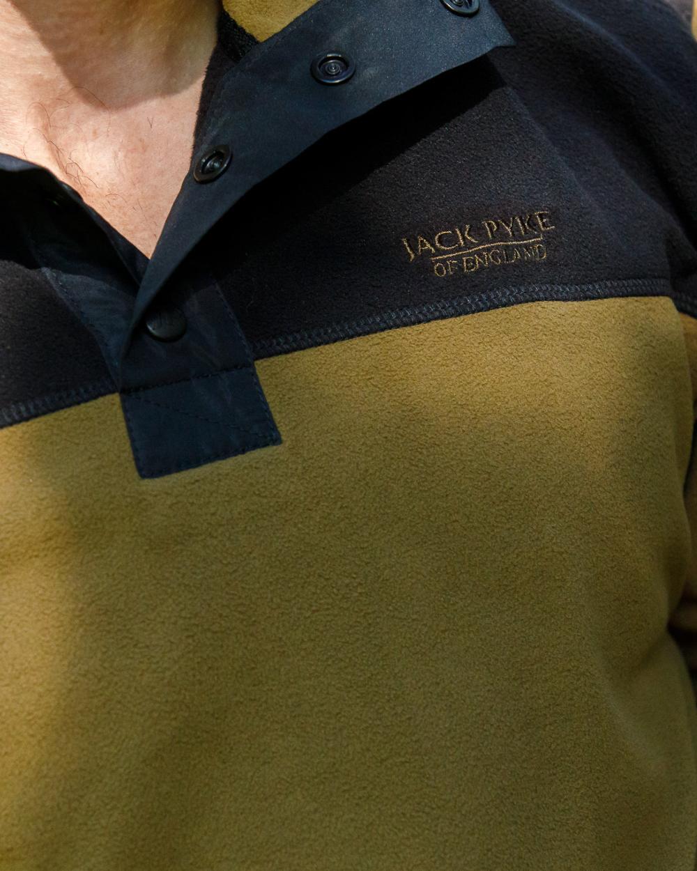 Dark Mustard coloured Jack Pyke Snap Neck Fleece Top on forest Background #colour_dark-mustard