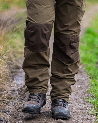 Green coloured Jack Pyke Weardale Hunting Trousers on forest background #colour_green