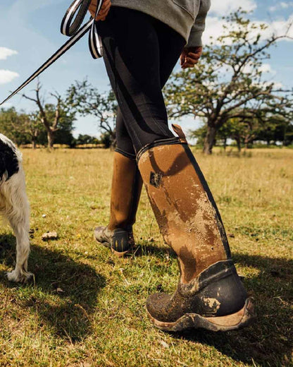 Black Tan Coloured Muck Boots Womens Arctic Adventure Tall Boots on outdoor background #colour_black-tan
