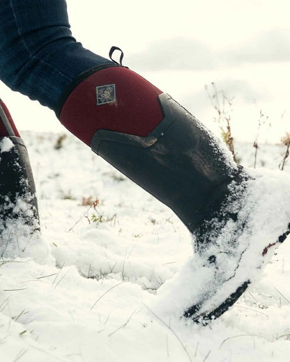 Black Windsor Wine coloured Muck Boots Womens Arctic Ice Tall Wellingtons on snow background #colour_black-windsor-wine