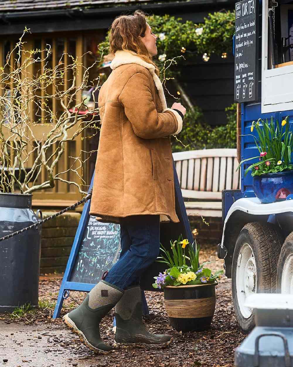 Olive Herringbone Print Coloured Muck Boots Womens Arctic Sport II Mid Wellingtons on countryside background #colour_olive-herringbone-print