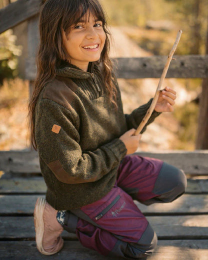 Plum Dark Anthracite coloured Pinewood Childrens Caribou TC Trousers on wooden bench background #colour_plum-dark-anthracite