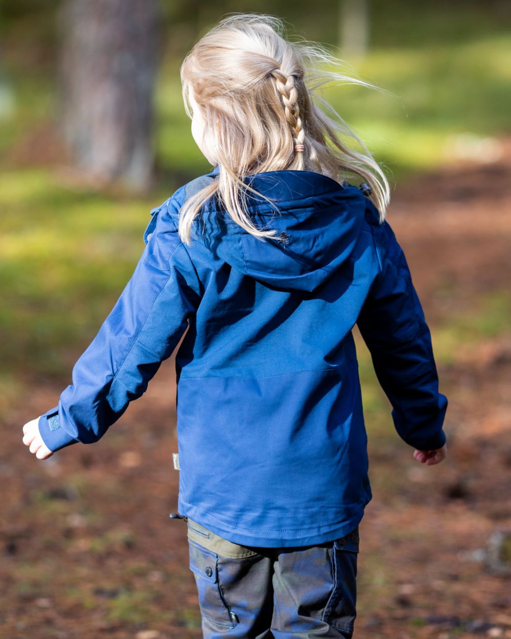 Dark Dive coloured Pinewood Childrens Finnveden Hybrid Jacket on forest background #colour_dark-dive