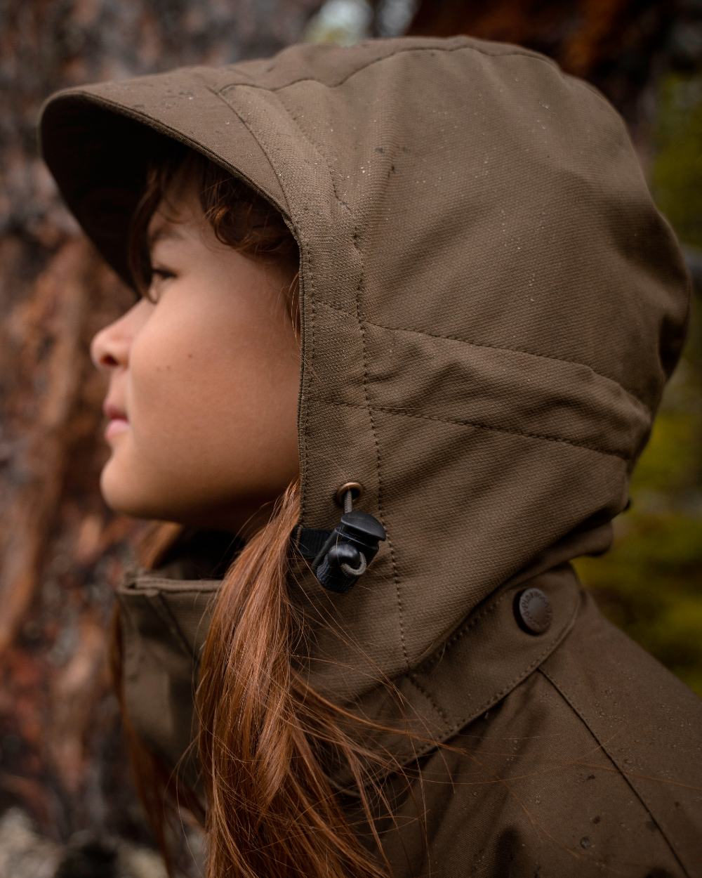 Hunting Olive coloured Pinewood Childrens Finnveden Hybrid Jacket on forest background #colour_hunting-olive