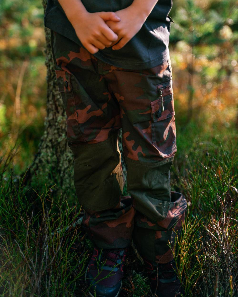 Dusty Plum Jungle coloured Pinewood Childrens Lappland Camou Trousers on forest background #colour_dusty-plum-jungle