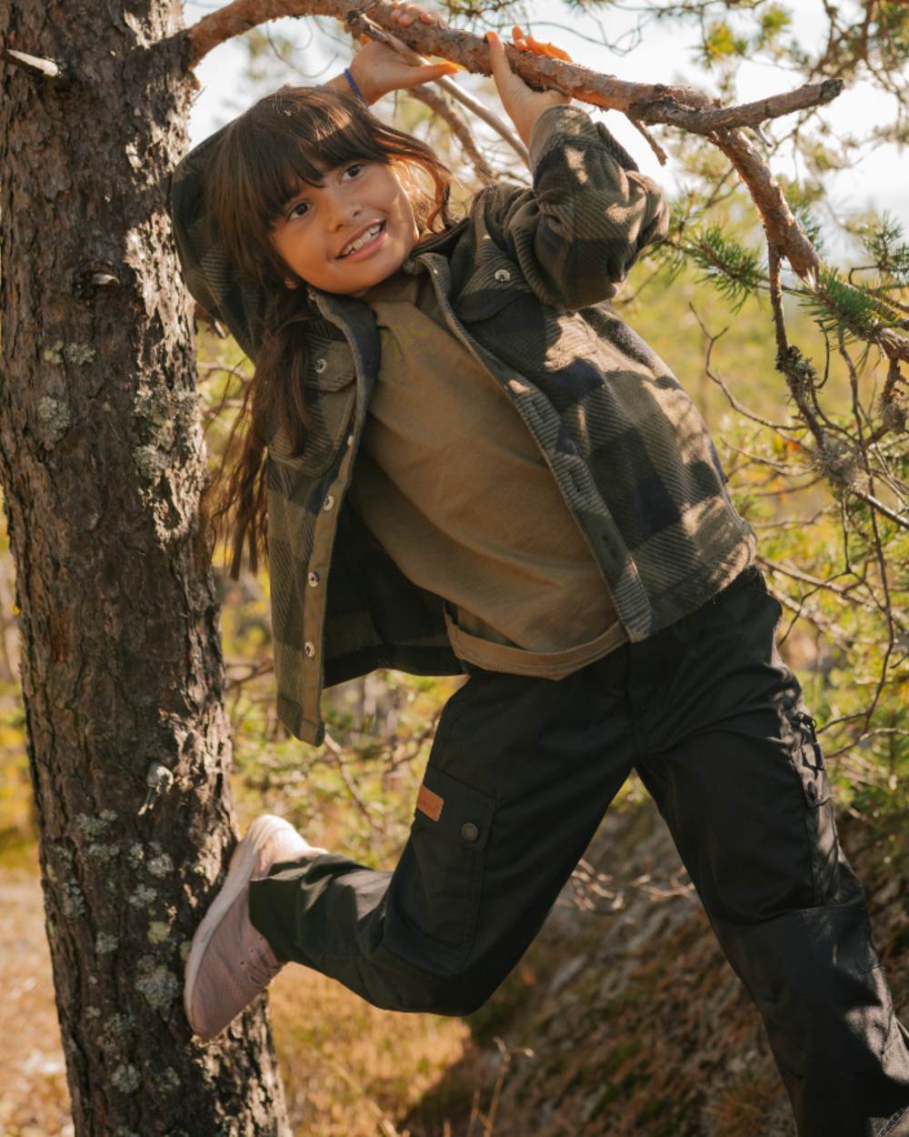 Black coloured Pinewood Childrens Lappland Trousers on forest background #colour_black