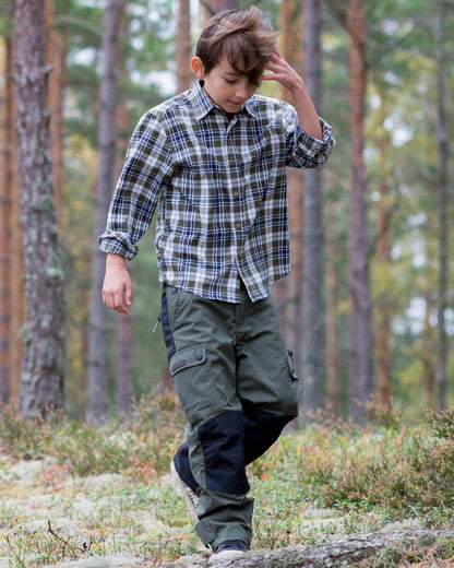 Mid Green Black coloured Pinewood Childrens Lappland Trousers on forest background #colour_mid-green-black