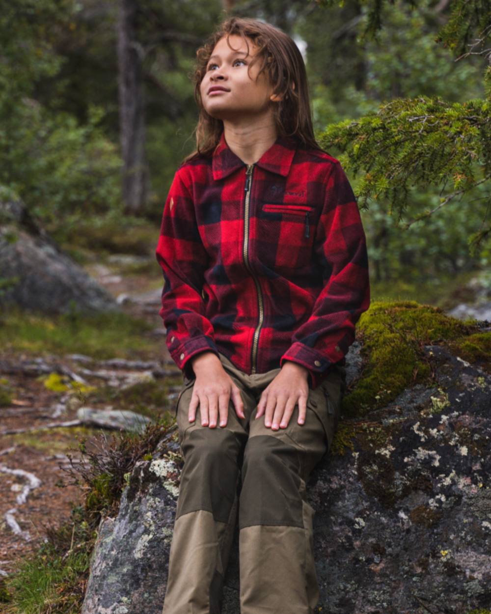Olive Moss Green coloured Pinewood Childrens Lappland Trousers on forest background #colour_olive-moss-green