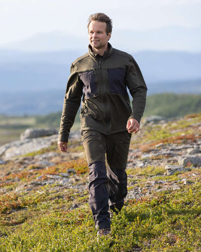 Moss Green Coloured Pinewood Mens Abisko Adventure Trousers on outdoor background #colour_moss-green