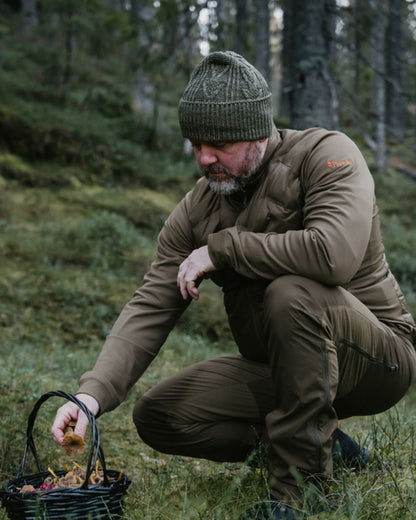 Olive Green Hunting Olive Coloured Pinewood Mens Abisko Brenton Trousers on forest background #colour_olive-green-hunting-olive