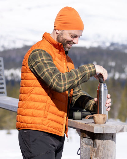 Burned Orange Coloured Pinewood Mens Abisko Insulation Vest on snow background #colour_burned-orange