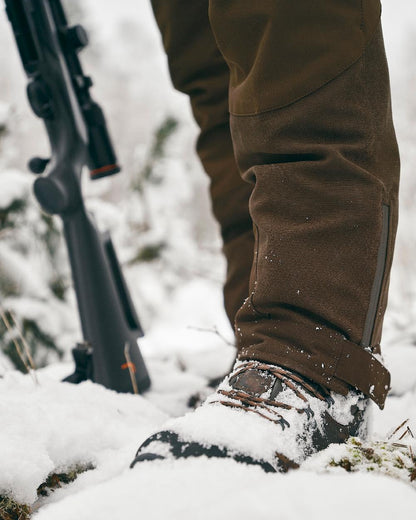 Suede Brown Dark Olive Coloured Pinewood Mens Caribou Hunt Extreme Trousers on snow background #colour_suede-brown-dark-olive