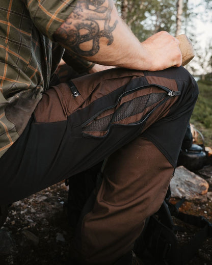 Dark Brown Black Coloured Pinewood Mens Caribou TC-Lite Trousers on outdoor background #colour_dark-brown-black