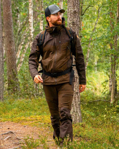 Dark Brown Coloured Pinewood Mens Finnveden Hybrid Trousers on outdoor background #colour_dark-brown