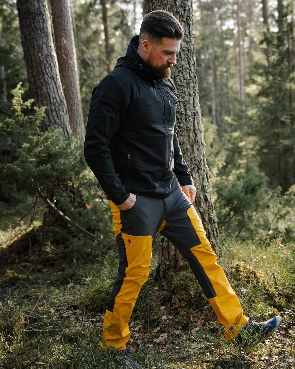 Black coloured Pinewood Mens Finnveden Hybrid Jacket on forest background #colour_black