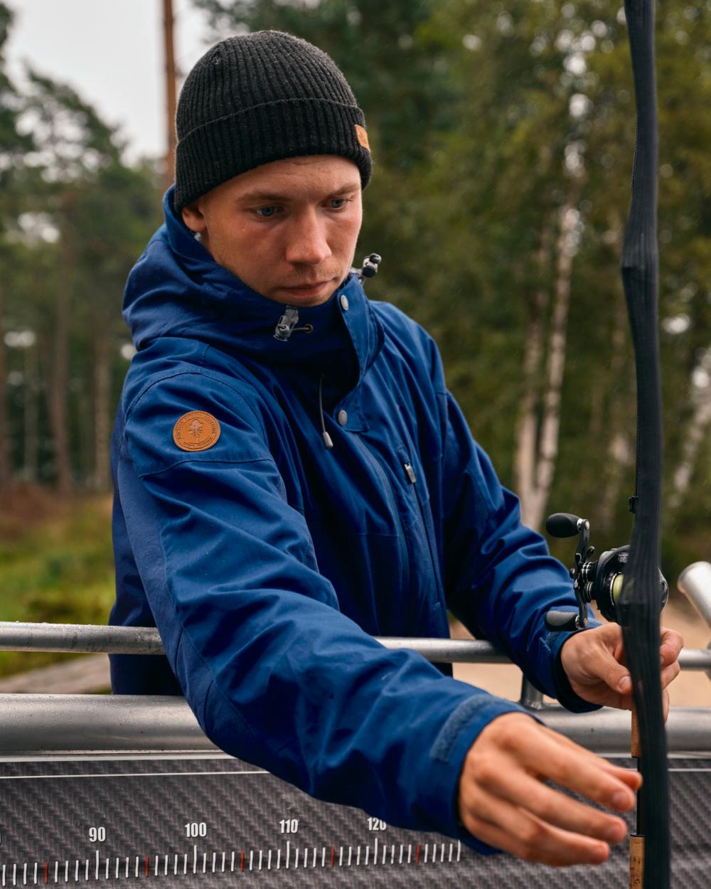 Dark Dive Coloured Pinewood Mens Finnveden Hybrid Jacket on forest background #colour_dark-dive
