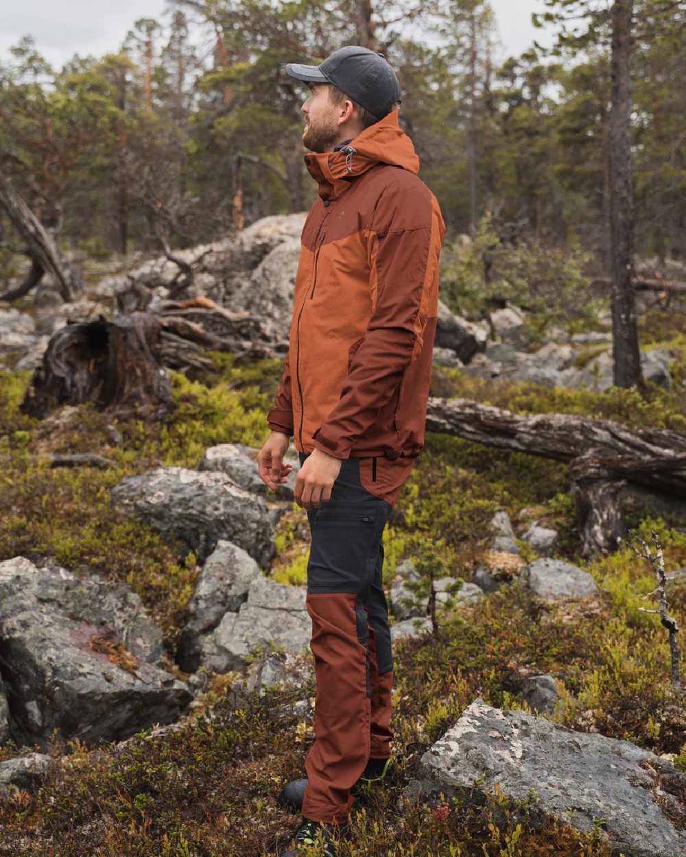 Terracotta coloured Pinewood Mens Finnveden Hybrid Jacket on forest background #colour_terracotta
