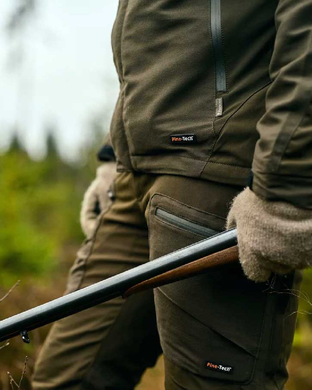 Moss Green coloured Pinewood Mens Hunter Pro Extreme 2.0 Jacket on forest background #colour_moss-green