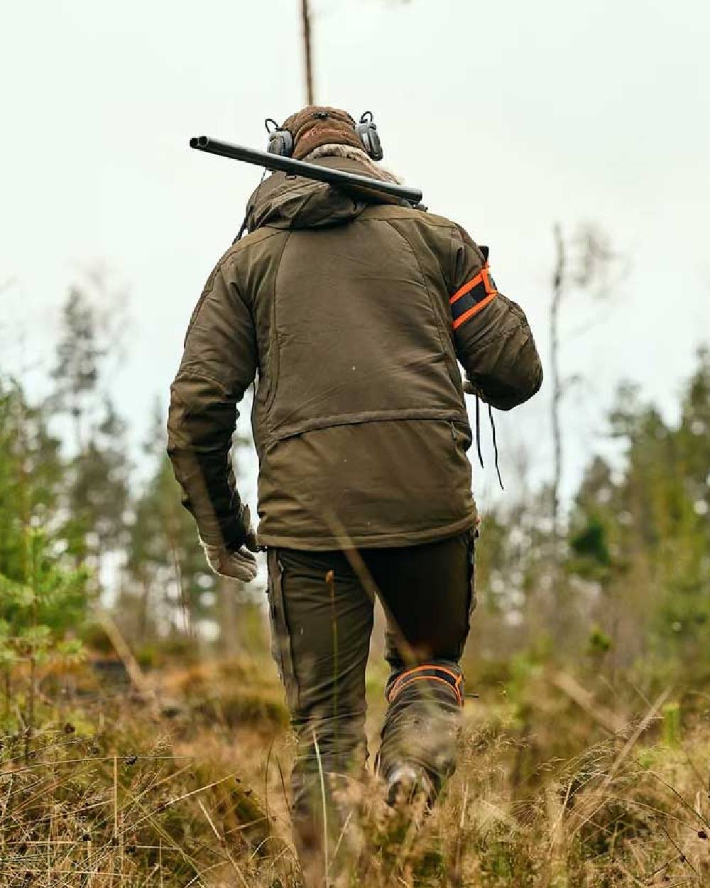 Moss Green coloured Pinewood Mens Hunter Pro Extreme 2.0 Jacket on forest background #colour_moss-green
