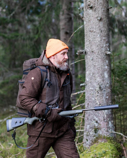 Suede Brown Coloured Pinewood Mens Smaland Abisko 2.0 Hunting Jacket on forest background #colour_suede-brown