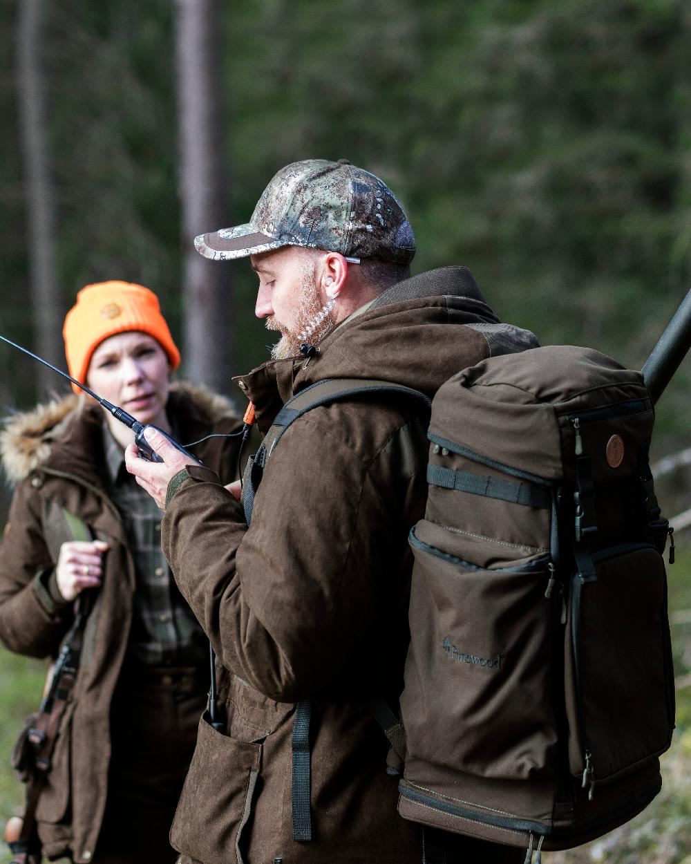 Suede Brown Coloured Pinewood Mens Smaland Abisko 2.0 Hunting Jacket on forest background #colour_suede-brown