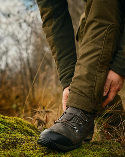Hunting Green coloured Pinewood Mens Smaland Forest Trousers on forest background #colour_hunting-green