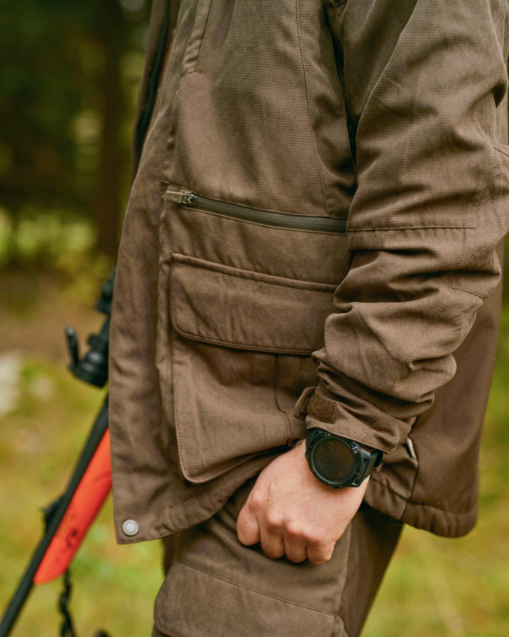 Suede Brown Coloured Pinewood Mens Smaland Hunters Jacket on forest background #colour_suede-brown