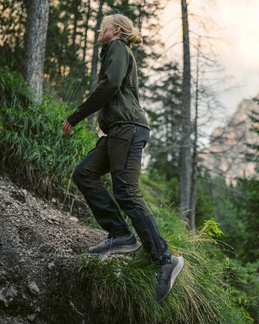 Moss Green Coloured Pinewood Womens Abisko Adventure Trousers on mountain background #colour_moss-green