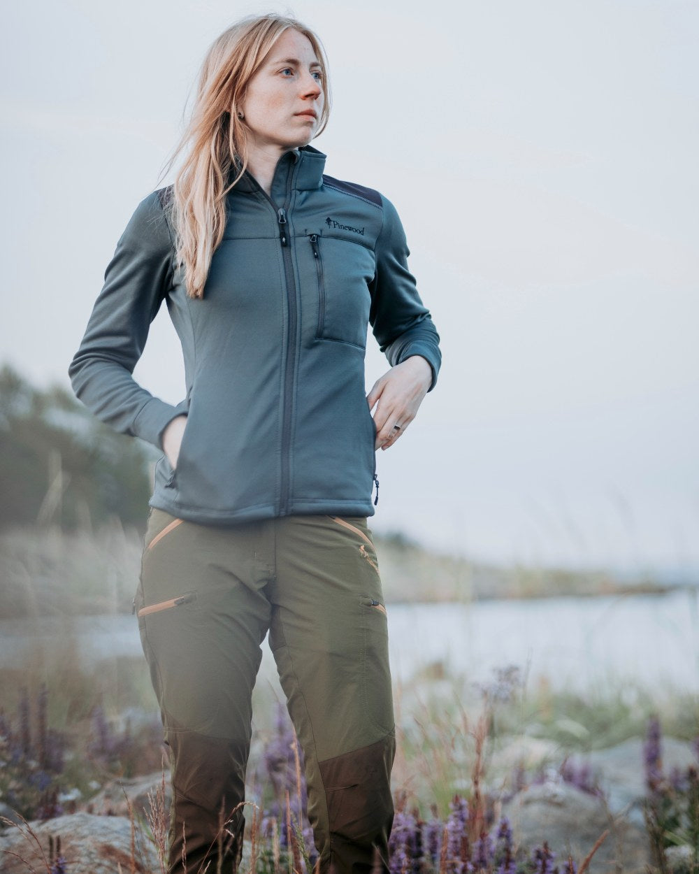Leaf Hunting Olive Coloured Pinewood Womens Abisko Brenton Trousers on lake background #colour_leaf-hunting-olive