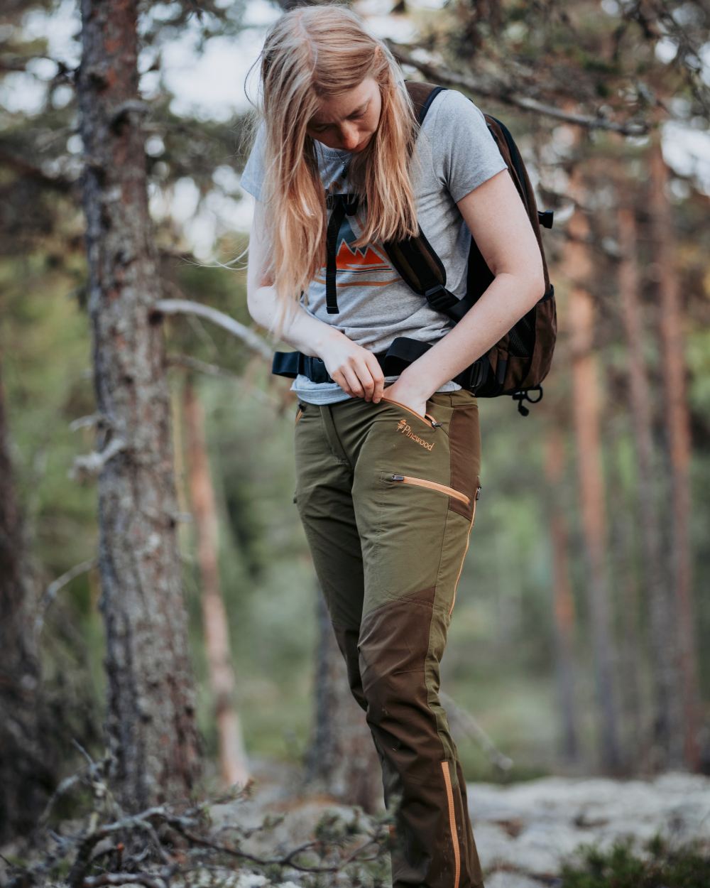 Leaf Hunting Olive Coloured Pinewood Womens Abisko Brenton Trousers on forest background #colour_leaf-hunting-olive