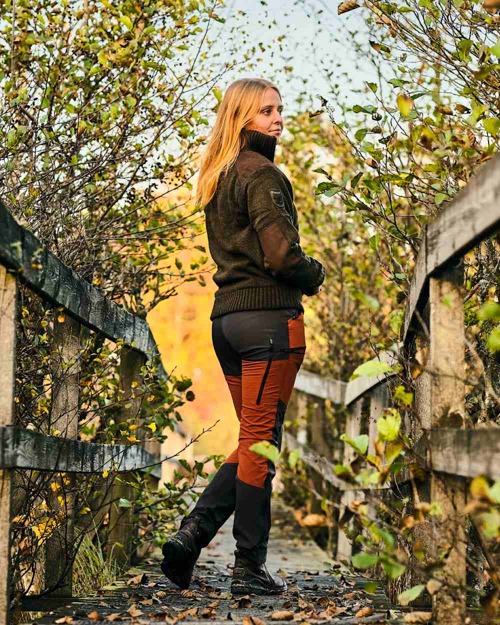 Terracotta Dark Anthracite Coloured Pinewood Womens Abisko Brenton Trousers on forest background #colour_terracotta-dark-anthracite