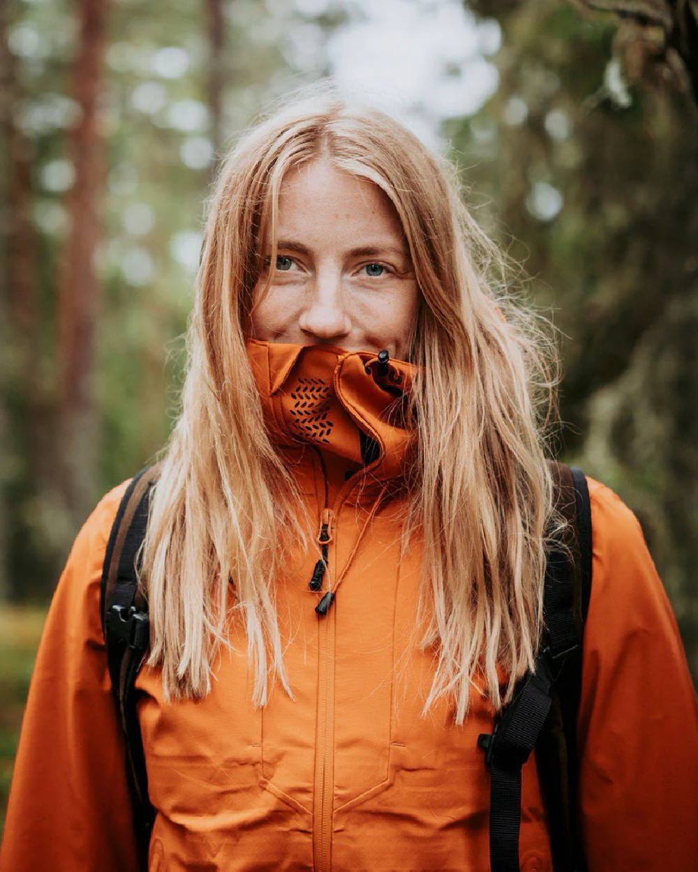 Burned Orange coloured Pinewood Womens Abisko Telluz Three Layer Jacket on blurry background #colour_burned-orange