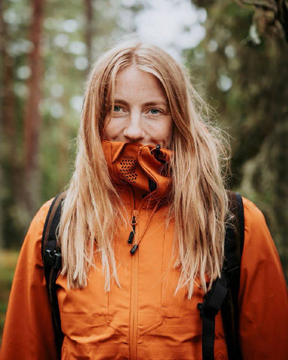 Burned Orange coloured Pinewood Womens Abisko Telluz Three Layer Jacket on blurry background #colour_burned-orange