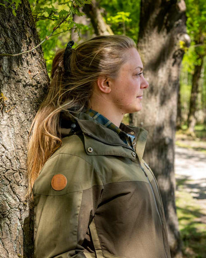 Dark Olive Hunting Olive Coloured Pinewood Womens Finnveden Hybrid Extreme Jacket on outdoor background #colour_dark-olive-hunting-olive