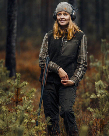 Mossgreen coloured Pinewood Womens Retriever Active Trousers on forest background #colour_moss-green