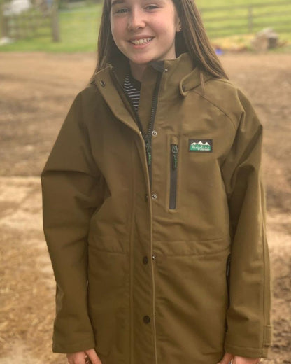 Teak coloured Ridgeline Kids Monsoon Classic Jacket on farm background #colour_teak