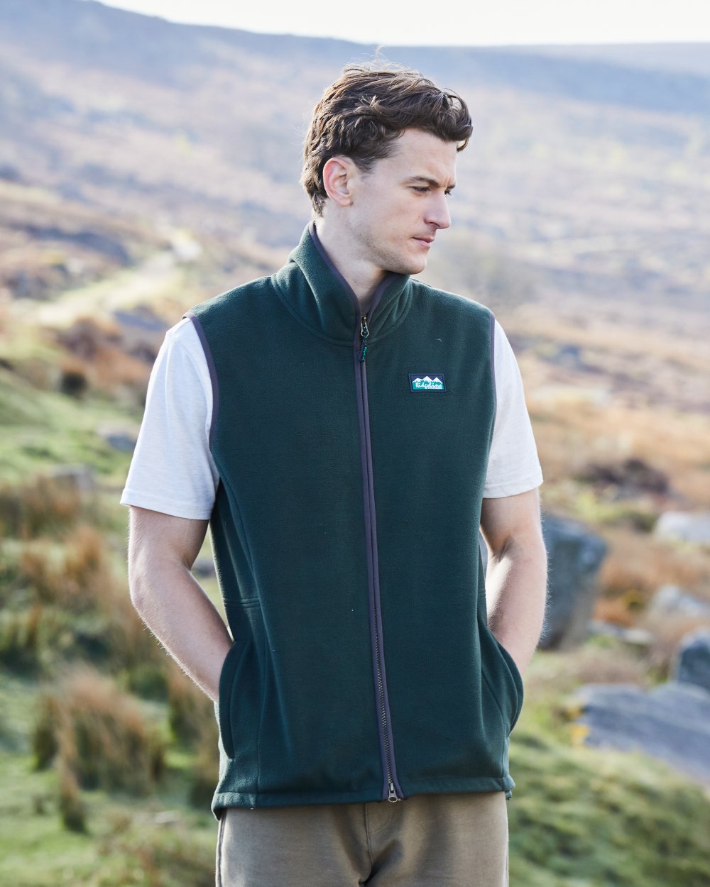 Deep Forest Coloured Ridgeline Mens Kodiak Gilet on hilly background #colour_deep-forest