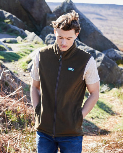 Moody Teak Coloured Ridgeline Mens Kodiak Gilet on hilly background #colour_moody-teak