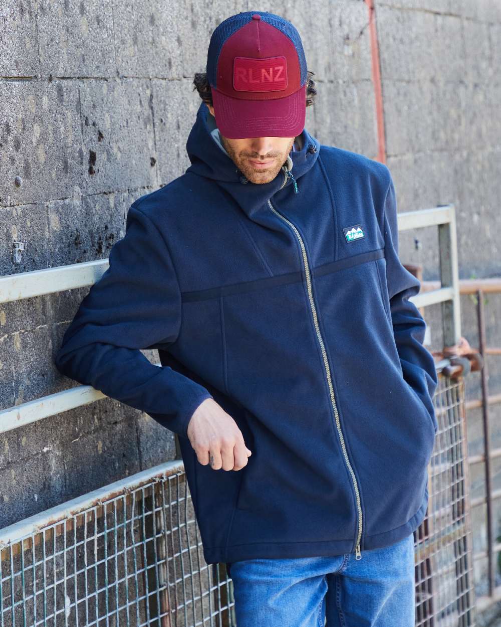 Rhubarb Coloured Ridgeline RLNZ Trucker Cap on outdoor background #colour_rhubarb