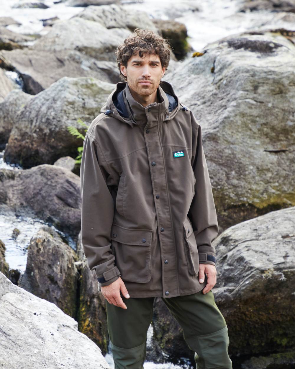 Bark coloured Ridgeline Torrent Waterproof Jacket on hilly  background #colour_bark