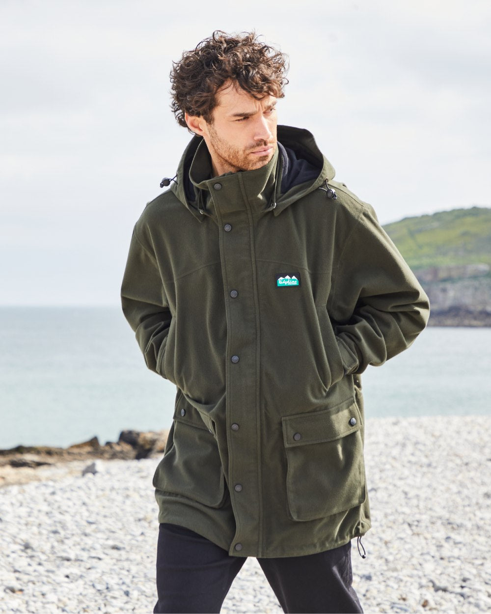 Deep Forest coloured Ridgeline Torrent Waterproof Jacket on beach background #colour_deep-forest