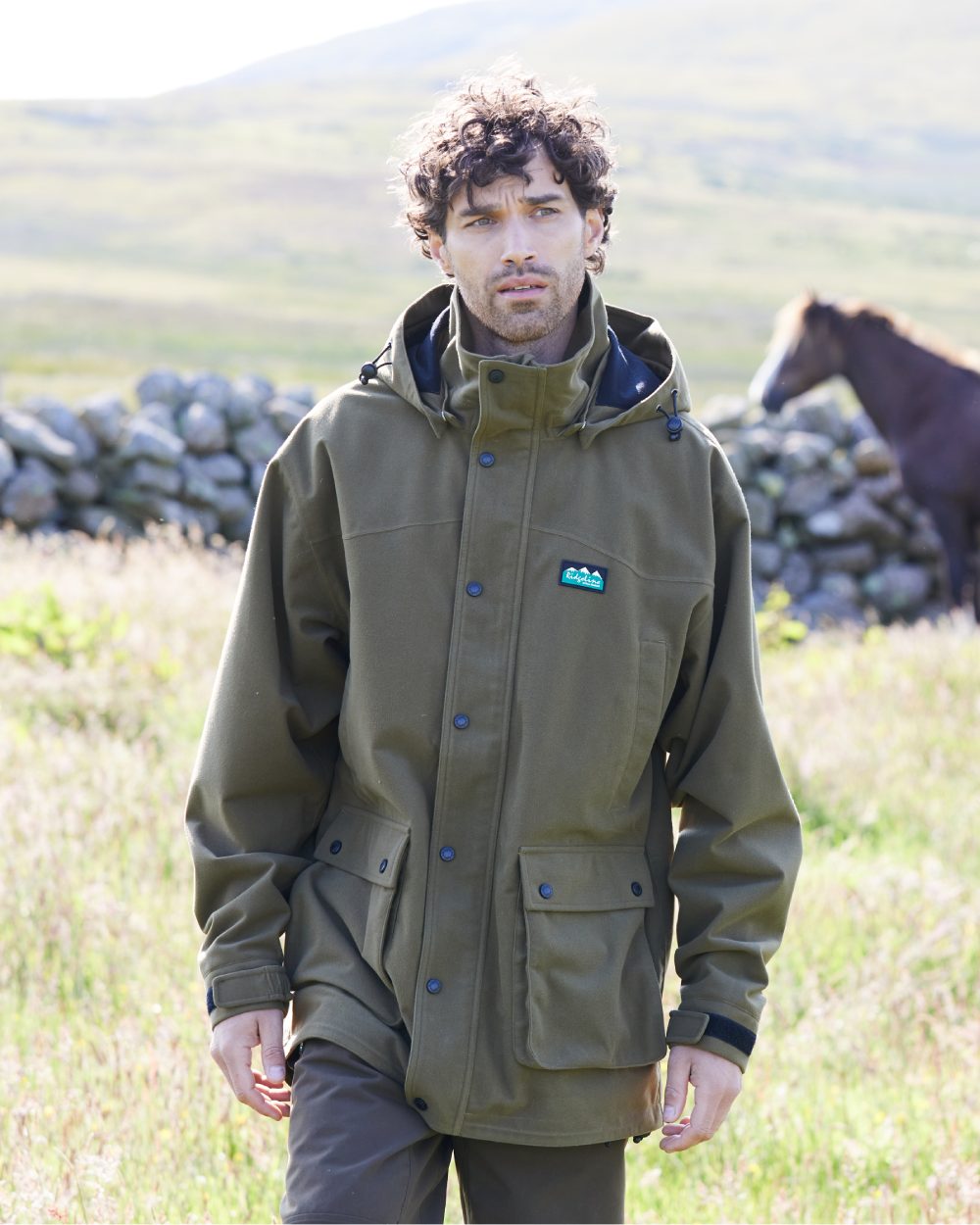 Teak coloured Ridgeline Torrent Waterproof Jacket on hilly background #colour_teak