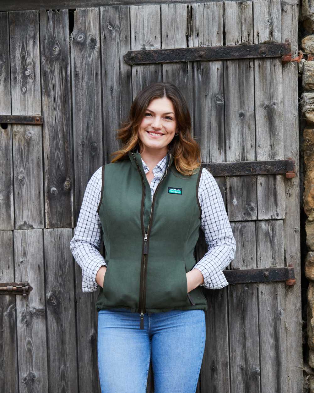 Deep Forest coloured Ridgeline Womens Monarch Gilet on door background #colour_deep-forest
