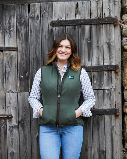 Deep Forest coloured Ridgeline Womens Monarch Gilet on door background #colour_deep-forest