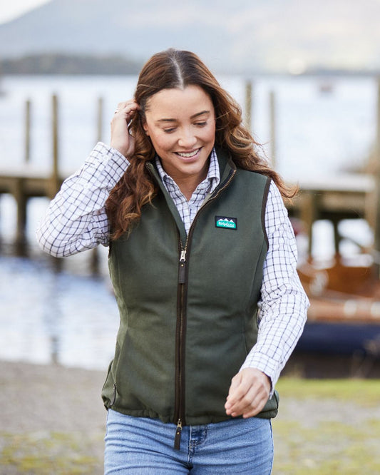 Deep Forest coloured Ridgeline Womens Monarch Gilet on blurry background #colour_deep-forest