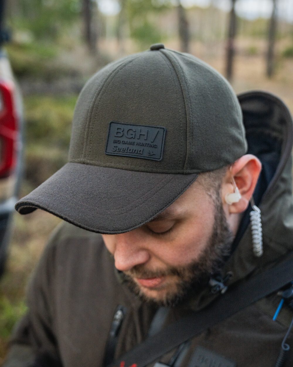 Pine Green coloured Seeland Chaser BGH Cap on forest background #colour_pine-green