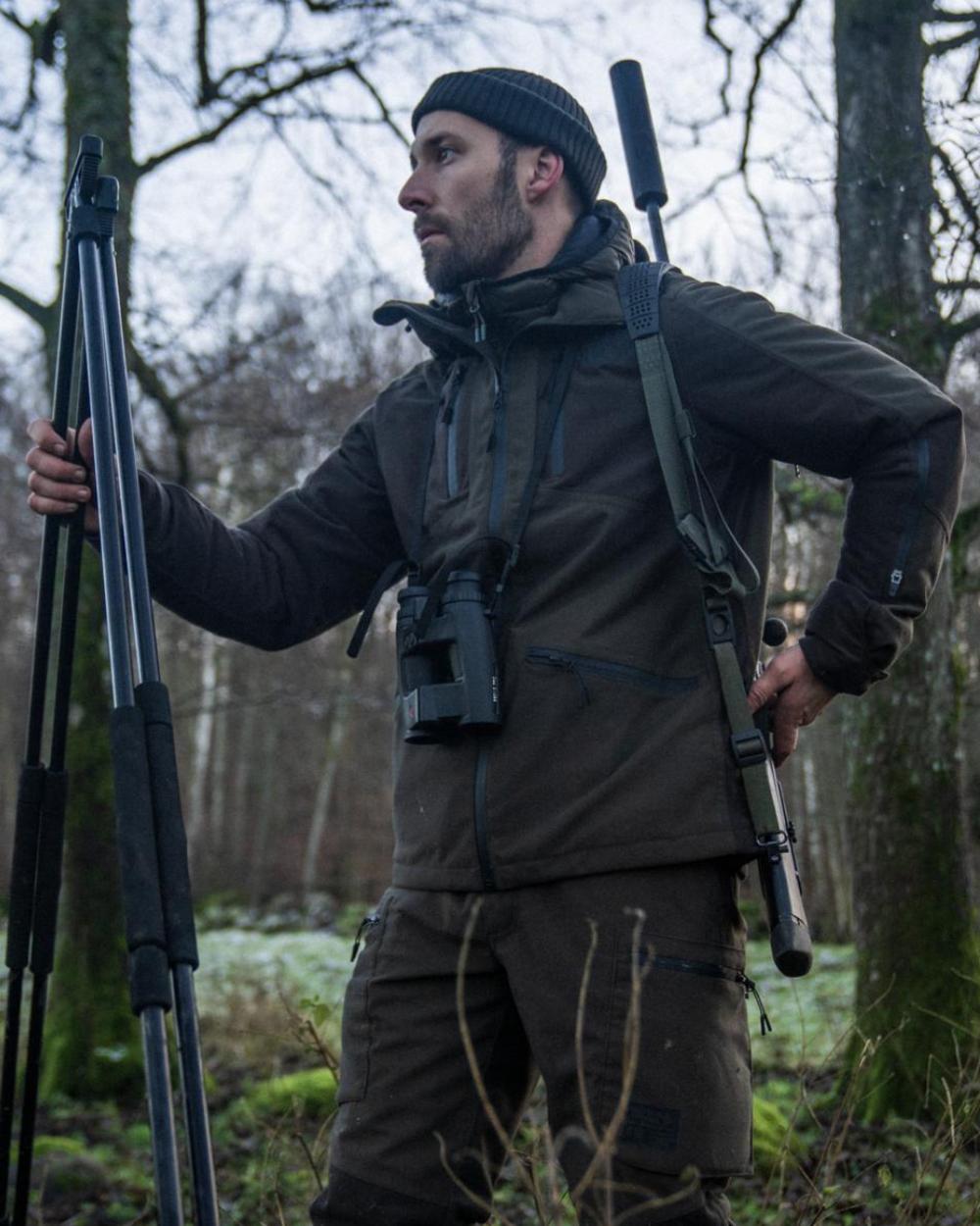 Pine Green Coloured Seeland Chaser Jacket on forest background #colour_pine-green